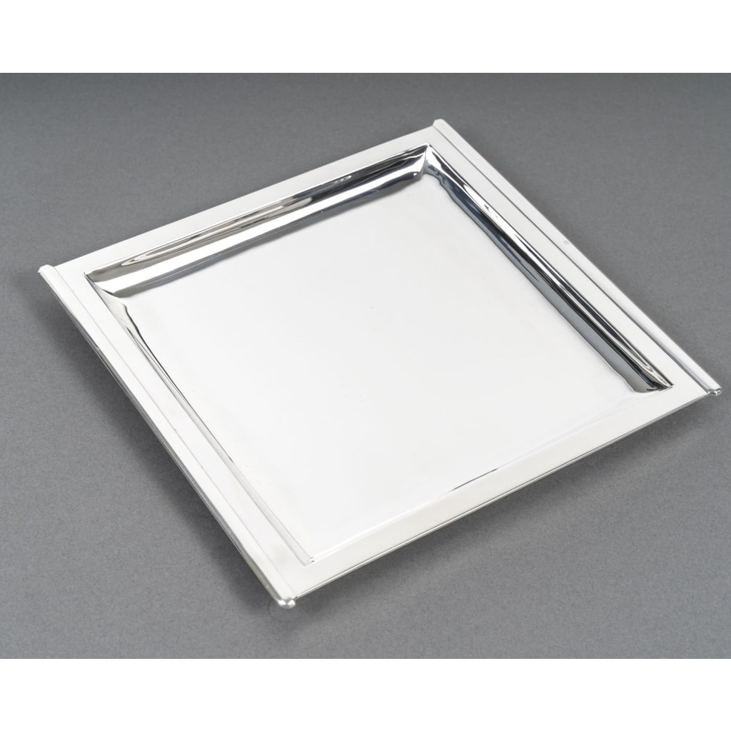 CARDEILHAC – Plat carré en argent massif époque ART DECO | Biron CARDEILHAC – Plat carré en argent massif époque ART DECO Plat carré en argent massif légèrement mi creux pourtour à gradins monté au marteau excellente qualité. Dimensions : longueur 26,5 cm – largeur 25 cm – hauteur 2 cm Matière : Argent 1er titre 950/°°° Poids : 684 grammes Poinçon : MINERVE Epoque : ART DECO vers 1930 Orfèvre : CARDEILHAC (écrit en toutes lettres) Origine : France/Paris