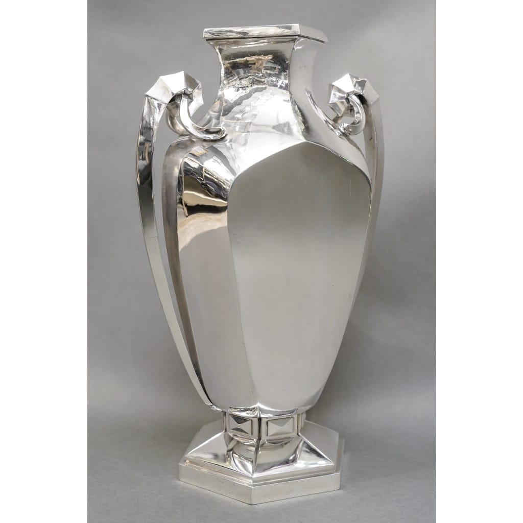 Orfèvre BOULENGER – Vase en argent massif ART DECO circa 1925/1930 | Biron Orfèvre BOULENGER – Vase en argent massif ART DECO circa 1925/1930 Grand vase en argent massif de forme balustre sur un piédouche hexagonal, agrémenté de deux anses latérales sur la hauteur. De formes très géométriques. Dimension : Hauteur 36,5 cm – largeur aux anses 23,5 cm Matière : Argent 1er titre 950/°°° Poids : 3.095 grammes Poinçon : MINERVE Epoque : ART DECO vers 1925/ 1930 Orfèvre : BOULENGER A PARIS Origine : France/Paris