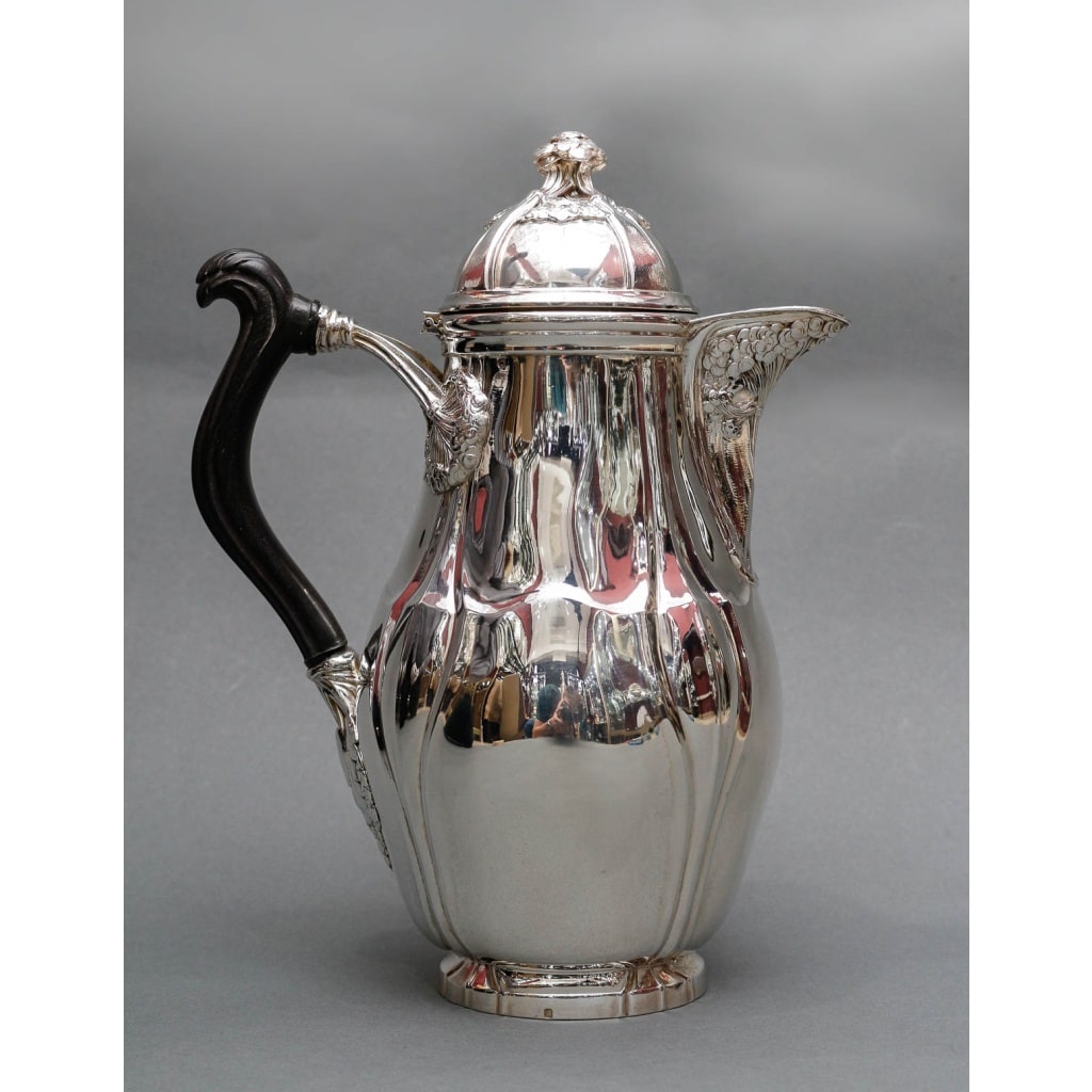 LELIÈVRE (Eugène-Alfred) – Cafetière en argent Massif TIFFANY circa 1880 ART NOUVEAU | Biron LELIÈVRE (Eugène-Alfred) – Cafetière en argent Massif TIFFANY circa 1880 ART NOUVEAU Grande Cafetière en argent massif à fond plat, corps ovoïde, anse en ébène sculpté, fixé avec un décor de fleurs en ombelle. On retrouve ce même décor sous le bec verseur et sur la prise du couvercle à charnière. Dimensions : Hauteur : 26 cm – largeur 19 cm diamètre base 13 cm Matière : Argent 1er titre 950/°°° Poids : 1000 grammes Poinçon : MINERVE Epoque : ART NOUVEAU vers 1880 Orfèvre : E. LELIEVRE Provenance : Edward CHANDLER MOORE (1827/1891) Orfèvre directeur de l’atelier de TIFFANY. – Appartenance Collection H. descendance du Précédent. Nombreuses pièces de sa collection sont exposées au M.M.A. de NEW-YORK. LELIÈVRE (Eugène-Alfred), élève de MM. Mittenholf et Philippe May- Boulevard. Richard-Lenoir, Paris né en 1856, à Montmartre, à la fin de sa vie en 1945 il demeurait 16 rue du grand prieuré Paris 16 -ème. Son atelier était au 14 bis rue des Minimes, Paris. Lelievre a exposé à La Société des Artistes Décorateurs, La Société des Artistes Français et La Société Nationale des Beaux-Arts EXPOSITION DES ARTISTES DECORATEURS dans la revue Le Panthéon de l’industrie de 1906.