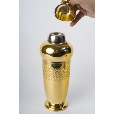TETARD Frères - SHAKER en Vermeil XXe ART DECO SHAKER en vermeil reposant sur un piédouche rond le corps de forme ovoïde est gravé à mi-corps d’un décor géométrique sur deux frises, renflé au niveau de la grille intérieur et recouvert d’un chapeau surmonté d’une sphère. Dimensions : hauteur 30 cm – base diamètre 8,5 cm Matériel : Argent vermeil 1er titre 950/°°° Poids : 896 grammes Poinçon : MINERVE Epoque : XXe vers 1930 Orfèvre : TETARD Frères à PARIS Origine : France/Paris