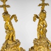 Paire de bougeoirs d’époque Napoléon III à décor de Putti en bronze doré, montée en lampes | Biron 