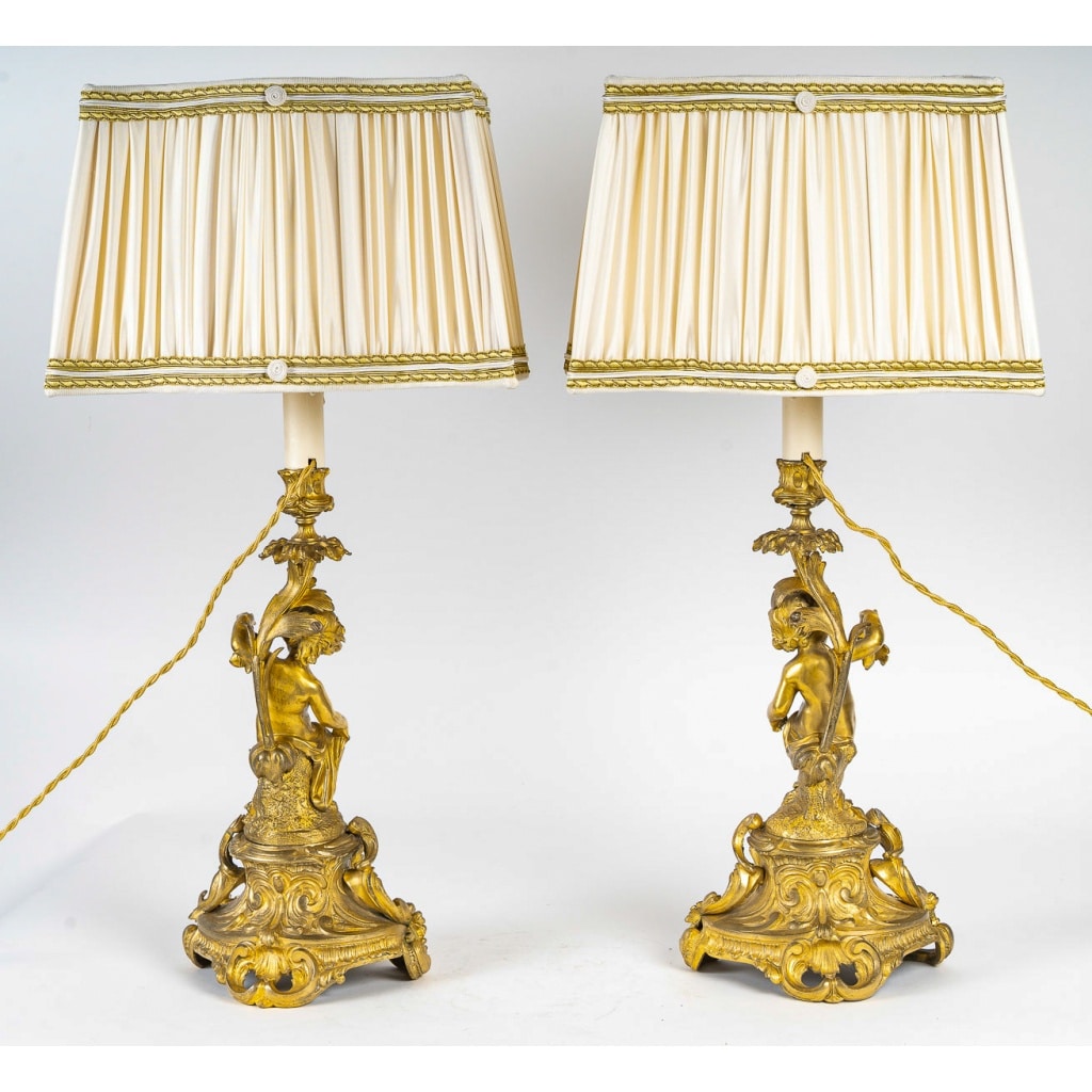 Paire de bougeoirs d’époque Napoléon III à décor de Putti en bronze doré, montée en lampes | Biron 