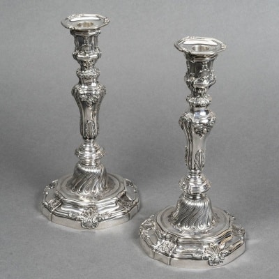 Orfèvre P.F.A. TURQUET – Paire de bougeoirs argent Louis XV - XIXe Paire de bougeoirs en argent massif de style Louis XV, la base ronde mouvementée est ornée de coquille, et surmontée d’un fût à décor de cannelures en partie basse, de feuilles d’acanthe, de guirlandes de fleurs de palmettes et enroulement de feuillage. Le binet est recouvert de sa bobèche. Dimensions : HAUTEUR 28,5 cm Matière : Argent 1er titre 950/°°° Poids : 1 kg.020 Poinçon : MINERVE Epoque : NAPOLEON III Orfèvre : Pierre-François-Augustin TURQUET Origine : France/Paris