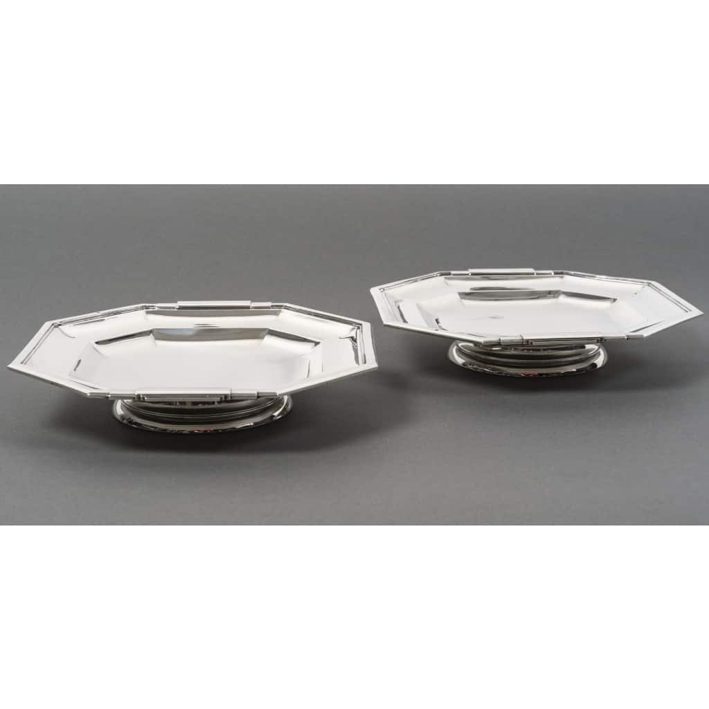 LAPPARRA – Paire de coupes sur pied argent massif XXe ART DECO | Biron LAPPARRA – Paire de coupes sur pied argent massif XXe ART DECO Paire de coupes en argent massif de forme hexagonale, montée sur un piédouche rond, mi-creux sur deux doucines, les bords en aplat et les prises de forme constructiviste sont représentées par deux demis arrondis superposés. Ces pièces sont travaillées au marteau . Dimensions : 24 cm x 23 cm – hauteur 4,5 cm Matière : Argent 950/°°° 1er titre Poids : 1 Kg 206 Poinçon : MINERVE Epoque : ART DECO vers 1930 Orfèvre : LAPPARRA à Paris Origine : France/Paris
