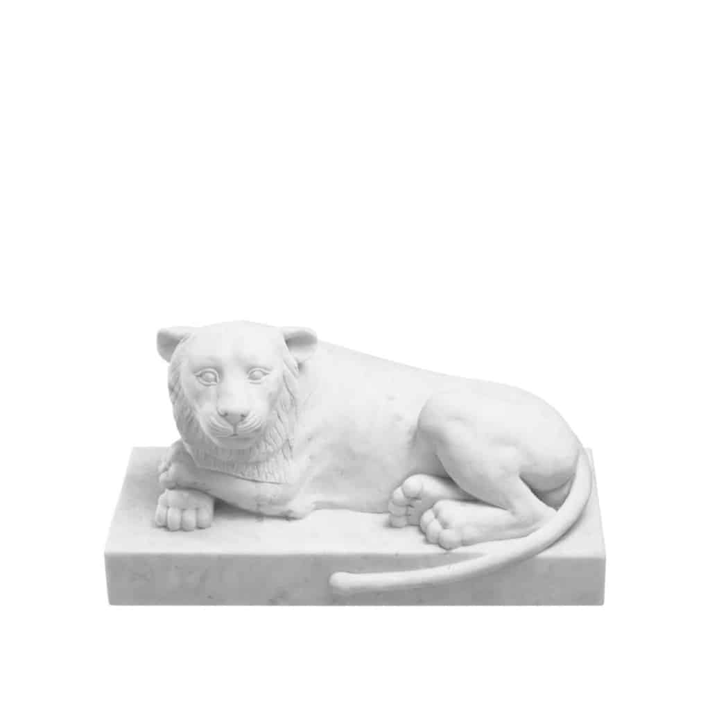 Sculpture d’un lion couché en marbre blanc, dans le gout de l’Egypte ancienne, XXème siècle. | Biron 