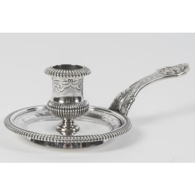 CARDEILHAC – Bougeoir à main en argent massif fin du XIXe siècle Bougeoir à main en argent massif de forme ronde, la soucoupe posée sur une batte, et le binet, sont ornés de godrons, et d’une ciselure à la Berain. L’anse est décorée de feuillage, de lambrequins et l’appui pouce est ciselé d’une tête de femme échevelée. Dimensions : longueur : 17,5 cm Diamètre soucoupe : 10 cm Hauteur : 5 cm Diamètre de la batte : 6,5 cm Poids : 200 Grammes Poinçon : MINERVE Orfèvre : CARDEILHAC A PARIS Origine : France/Paris