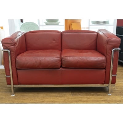 "Le Corbusier (1887-1965), Charles Edouard Jeanneret & Charlotte Perriand (1903-1999)" Canapé 2 places Canapé 2 places en cuir rouge assise avec coussins, structure en métal chromé brillant. Garniture recouverte d’un cuir rouge patiné très bon état. Edition Cassina signée Dimensions : Longueur : 130 cm Profondeur : 70 cm Hauteur totale : 68 cm Hauteur de l’assise : 45 cm Matière : cuir et métal chromé Epoque : XXe