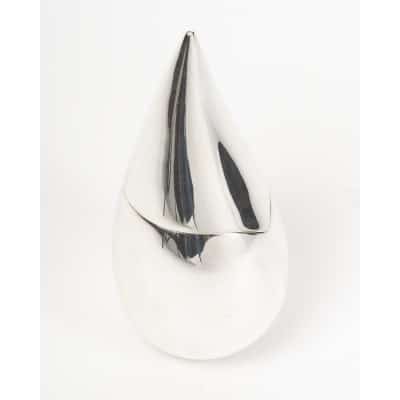 Cette pièce en argent CHRISTOFLE – boite en argent massif moderniste XXIe siècle massif adopte une forme moderne et épurée de GOUTTE D’EAU STYLISEE. Sa silhouette lisse, élancée et symétrique est marquée par un point culminant très fin lui conférant une élégance sculpturale. Cette pièce contemporaine allie pureté des lignes et raffinement du matériau, illustrant l’esprit novateur de la maison CHRISTOFLE au XXIe siècle. Cette pièce éditée à 1000 exemplaire porte le N°779. Cet objet est une véritable sculpture. Dimensions : hauteur 20 cm - Envergure maxi : 10 cm Diamètre base : 4 cm Matière : argent 1er titre 950/°°° Poids : 422 grammes Poinçon : MINERVE Epoque : XXIe siècle Orfèvre : CHRISTOFLE Origine : France/Paris