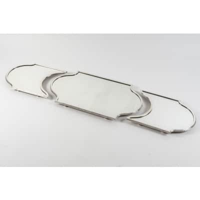 Orfèvre QUEILLE - Surtout de table en argent massif 3 parties XIXe NAPOLEON III Important surtout de table en trois parties de style Louis XVI, à fond de miroirs, sur un parquet de bois, serti d'une forte lingotière en argent massif à filets et rubans croisés, monté sur des pieds toupies. Dimensions : longueur totale 139 cm Milieu : 74 cm x 42 cm x 4 cm 1/2 cotés : 42 cm x 35,5 cm Matière : argent 1er titre 950/°°° Poinçon : MINERVE Epoque : XIXè NAPOLEON III Orfèvre : QUEILLE à PARIS Origine : France/Paris
