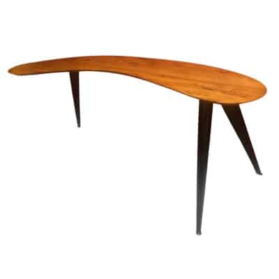 Bureau Boomerang de style design en bois fruitier reposant sur trois pieds en métal.