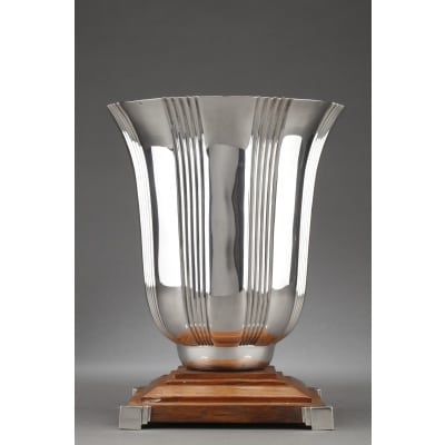 LAPPARRA - Vase en argent massif époque ART DECO Grand vase en argent massif de forme balustre décoré de rainures verticales, fixé sur un socle en bois à dégrés serti d'argent au quatre coins . Dimensions : hauteur : 27,5 cm - diamètre 21,5 cm - base 17,5 cm Matière : argent 1er titre 950/°°° Poids brut : 2.475 grammes brut Poinçon : Minerve Epoque : ART DECO Orfèvre : LAPPARRA à PARIS Origine : FRANCE
