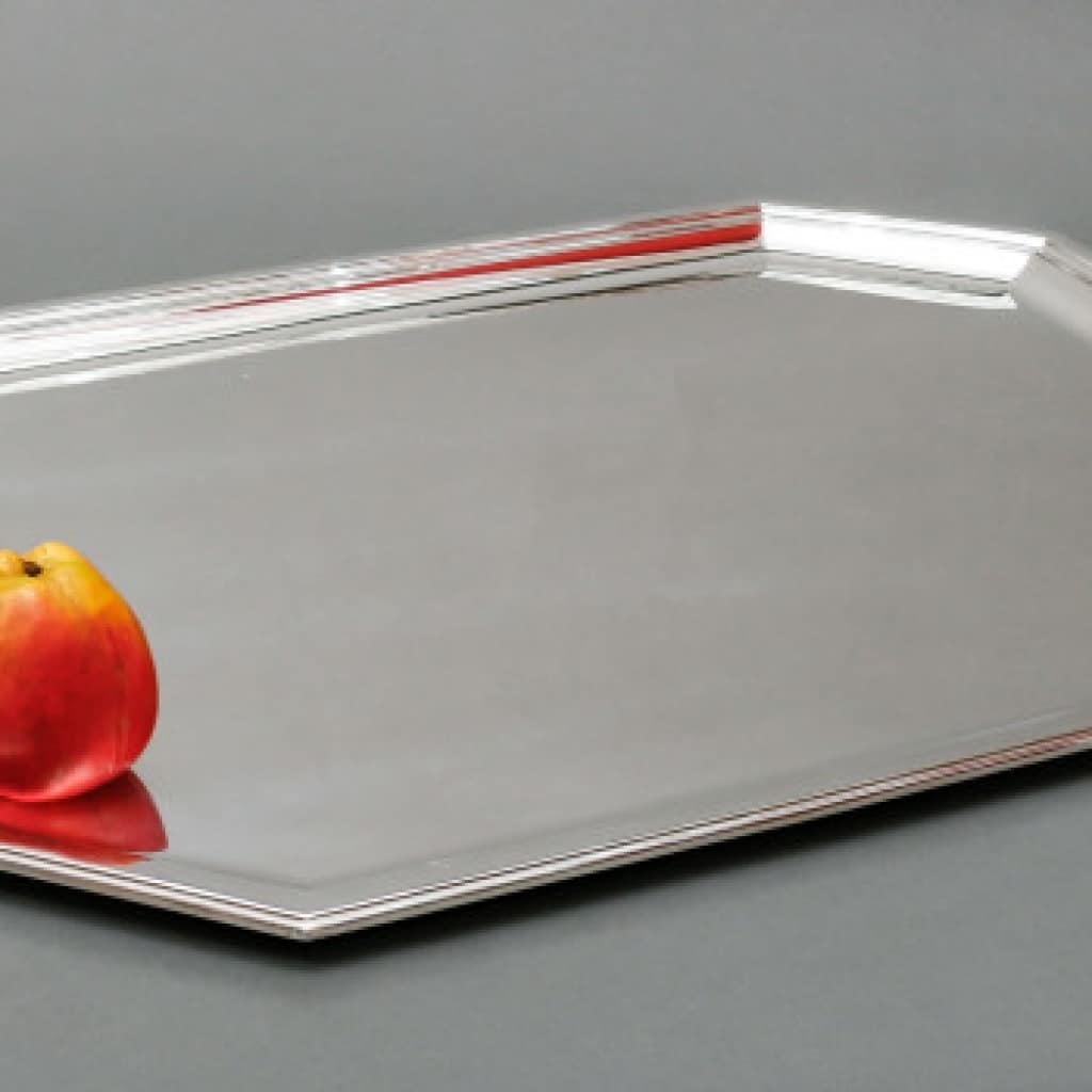 TETARD - Plateau en argent massif ART DECO circa 1930 Plateau de forme octoganale monté au marteau, pourtour en aplat a double filet, flanqué de chaque côté d'anses geométriques. Dimensions : longueur : 69 cm avec anses, 60 cm sans anses Largeur : 48 cm - hauteur 2 cm Matière : Argent 1er titre 950/°°° Poids : 5000 grammes env. Poinçon : MINERVE Epoque : ART DECO vers 1930 Orfèvre : TETARD Frères écrit en toutes lettres Provenance : FRANCE/ PARIS