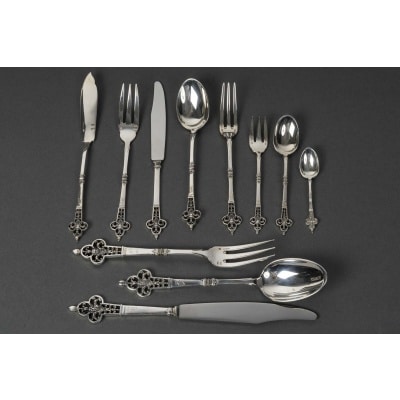CARDEILHAC - MENAGERE 150 PIECES EN ARGENT MASSIF MODELE " RENAISSANCE" XXe Le manche repercé est orné d'un mascaron seules les cuillères a moka ne sont pas repercées. Commande faite pour l'exportation . Poinçons : STERLING FRANCE A 925 - Poinçon de Maître de CARDEILHAC - Poinçon d'exportation de CHRISTOFLE ( OC) Poinçon de C. CHRISTOFLE dans un losange. POIDS : Poids des pièces de table 6Kg 144 grs + poids des pièces de service 1 Kg 471 POIDS NET TOTAL : 7 Kgs 615 grammes POIDS BRUT DES COUTEAUX : 1 kg 542 grs Composition :  12 FOURCHETTES DE TABLE  12 CUILLERES DE TABLE  12 COUTEAUX DE TABLE  12 FOURCHETTES A POISSON  12 COUTEAUX A POISSON  12 CUILLERES A ENTREMET  12 FOURCHETTES A ENTREMET  12 COUTEAUX A ENTREMET  12 FOURCHETTES A GATEAUX  12 CUILLERES A MOKA  12 CUILLERES A THE / CAFE + 18 PIECES DE SERVICE soit : - 1 COUVERT A SALADE 2 PIECES  1 CUILLERE A SAUCE  1 PELLE A TARTE  1 COUVERT A POISSON 2 PIECES  1 LOUCHE  4 PIECES DE SERVICE DE TABLE  1 COUTEAU A BEURRE  1 COUTEAU A FROMAGE  1 PINCE A SUCRE  4 PIQUES A HORS D’ŒUVRES En 1951, la maison Cardeilhac est rachetée par Christofle, qui perpétue une partie de ses modèles et conserve l’héritage de son savoir-faire. Aujourd’hui, les pièces signées Cardeilhac sont très recherchées pour leur élégance et leur qualité de fabrication, illustrant l’âge d’or de l’orfèvrerie française.